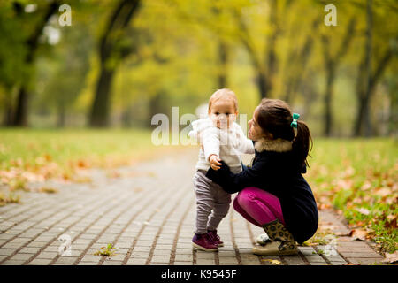 Two little girl's sisters in the autumn park Stock Photo