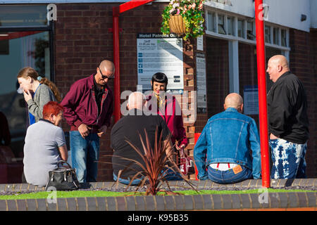 Fans of ska sit and chat outside the Grand Burstin Hotel in Folkstone. Skabour weekender. Stock Photo