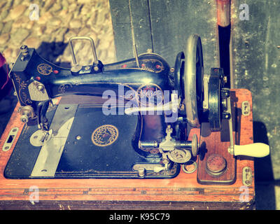 old sewing machine on wood surface out of use Stock Photo