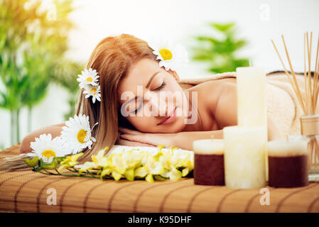 Beautiful young woman enjoying during a skincare treatment at a spa. She is relaxing with eyes closed. Stock Photo