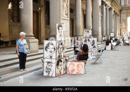 Florence, Italy - September 25, 2016: Paintings sold on street in Florence near Uffizi gallery. Florence is a popular tourist destination and many str Stock Photo