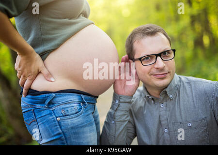 Family together in the autumn park. Woman is pregnant Stock Photo