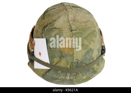 US Army helmet Vietnam war period with camouflage cover and ammo belt, dog tag and amulet - playing card ace of diamonds Stock Photo