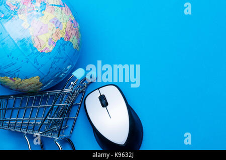 Shopping cart on a blue background with computer mouse and globe Stock Photo