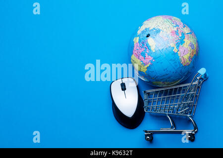 Shopping cart on a blue background with computer mouse and globe Stock Photo