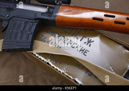 SVD sniper rifle with box of ammunition on canvas background. The inscription translates as 'Snipers Ammunitions' Stock Photo