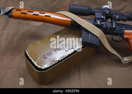 SVD sniper rifle with box of ammunition on canvas background. The inscription translates from russian as 'Snipers Ammunitions' Stock Photo