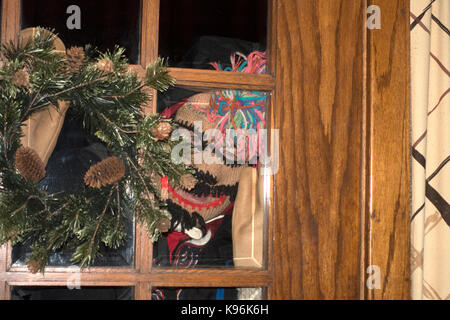 Infamous photographer Steve Skjold peering through door dressed in winter walking gear. St Paul Minnesota MN USA Stock Photo