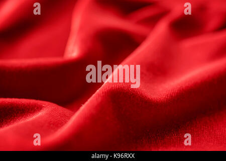 Red silk velvet close up with selective focus. Abstract defocused background Stock Photo
