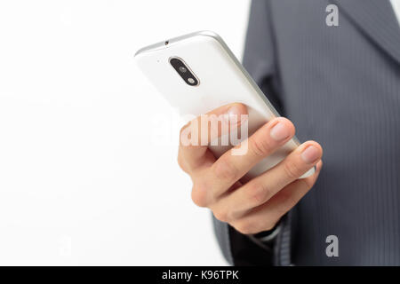 Business man with a white cell phone in his hand. Background white, gray striped suit. Stock Photo