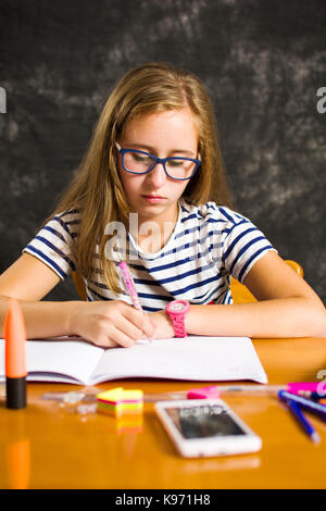 Bored teenage girl doing homework assignment at home Stock Photo