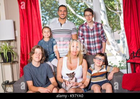 Family of six on the sofa in the living room Stock Photo