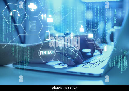 Businessman with fintech icon and internet of things with matrix code background , Investment and financial internet technology concept. Stock Photo