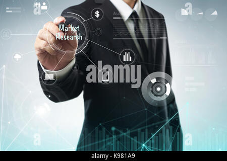 Businessman draw "Market Research" word on digital virtual screen . Hi-tech business concept . Stock Photo
