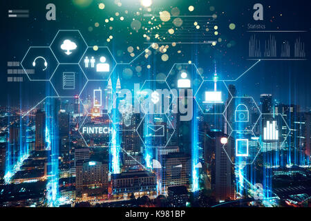"Fintech" word on digital virtual screen with futuristic city skyline. Hi-tech business concept . Stock Photo