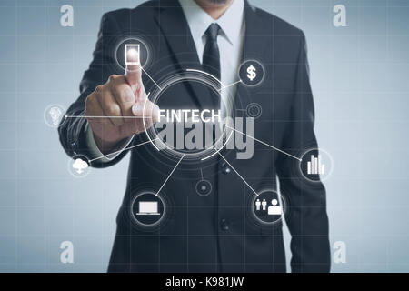 Businessman with fintech icon and internet of things with matrix code background , Investment and financial internet technology concept. Stock Photo