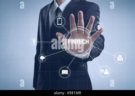Businessman with fintech icon and internet of things with matrix code background , Investment and financial internet technology concept. Stock Photo