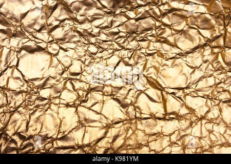 Golden background, shiny creased paper, antique, vintage backdrop. Bronze texture Stock Photo