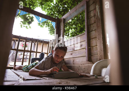 Boy using digital tablet in log cabin Stock Photo