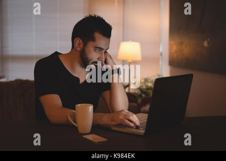 Man using laptop in the living room at home Stock Photo
