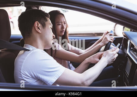 Couple using mobile phone in the car Stock Photo