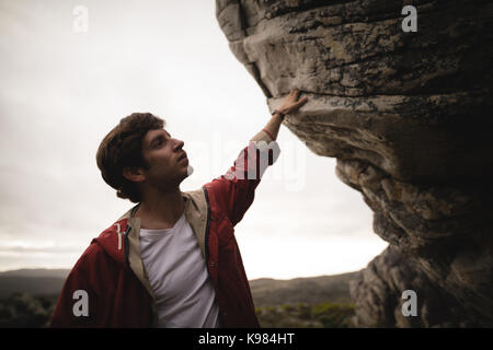 Man standing under cliff on a sunny day Stock Photo