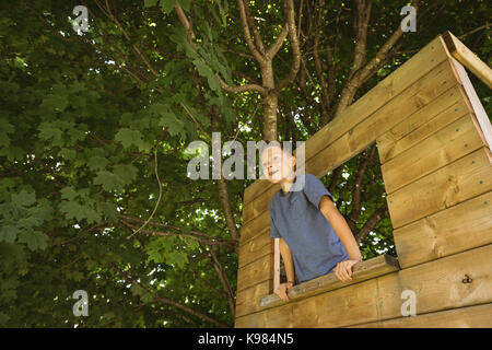 Happy boy looking through window in playground Stock Photo