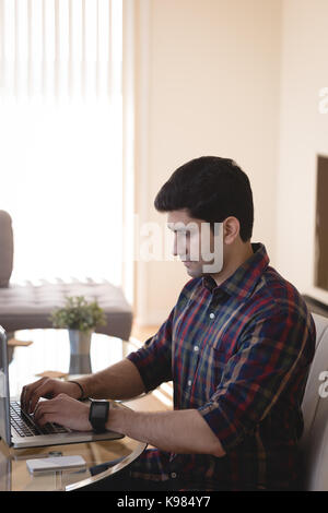 Man using laptop in living room at home Stock Photo