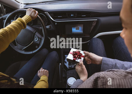 Man giving gift to woman in car Stock Photo
