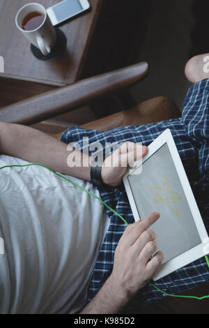 Mid-section of man using digital tablet at home Stock Photo