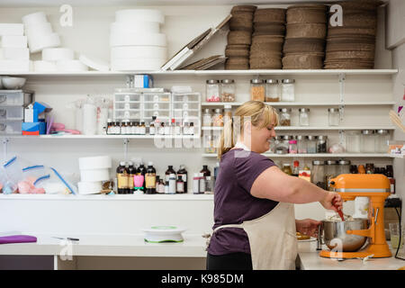 Smiling woman preparing cake batter in the kitchen at home Stock Photo