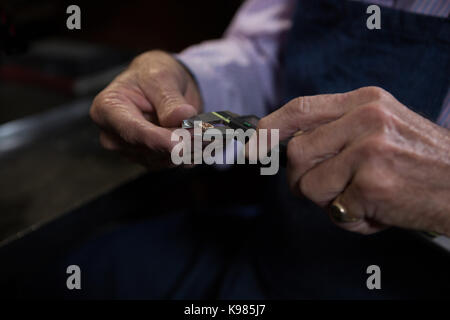 Close-up of goldsmith using a tool in workshop Stock Photo