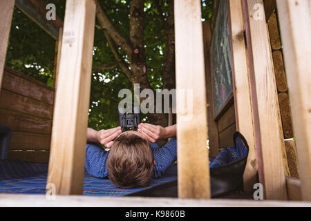 Boy looking through binoculars in playground Stock Photo