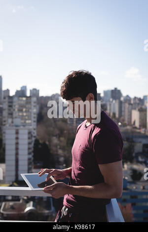 Smiling man using digital tablet on terrace Stock Photo