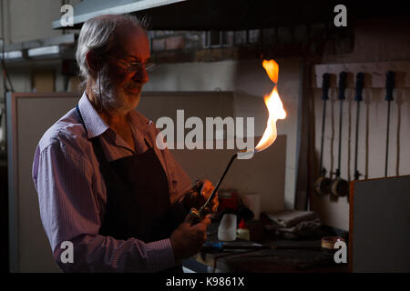 Senior goldsmith using welding torch in workshop Stock Photo