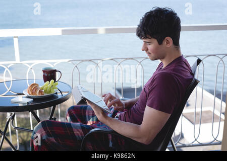 Handsome man using digital tablet on terrace Stock Photo