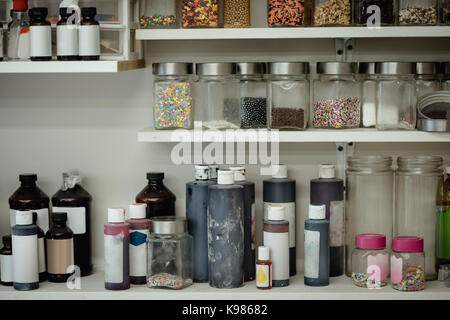 Various ingredient bottles kept in shelf at kitchen Stock Photo