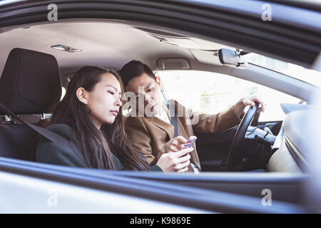 Couple using mobile phone in the car Stock Photo