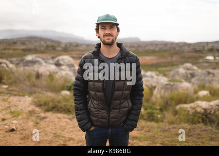 Portrait of confident man standing with hands in pockets Stock Photo