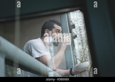 Man having breakfast in the balcony at home Stock Photo