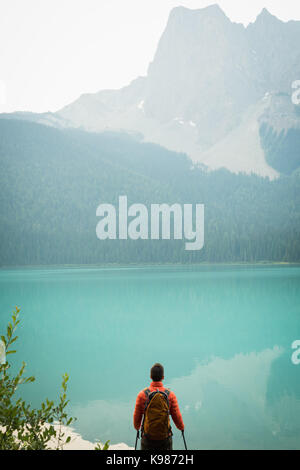 Rear view of hiker standing near the lake in countryside Stock Photo