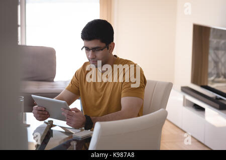 Man using digital tablet in living room at home Stock Photo