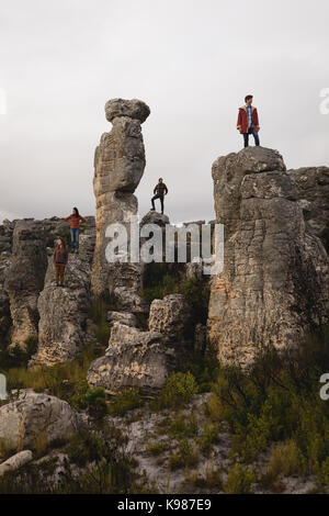Friends standing on top of the cliff on a sunny day Stock Photo