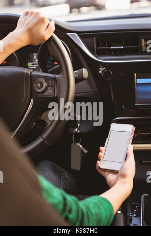 Mid-section of woman using mobile phone while driving car Stock Photo