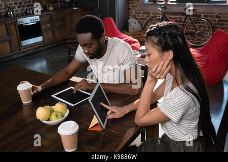 couple using tablets on kitchen Stock Photo