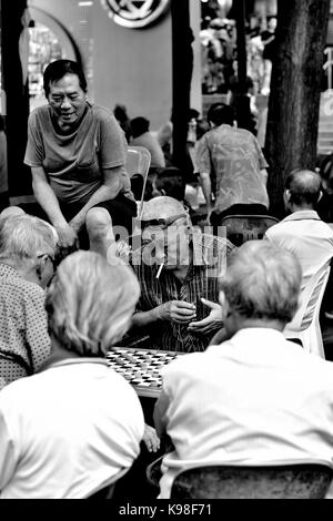 A group of elderly Chinese men playing traditional Chinese Chess in Chinatown, Singapore Stock Photo