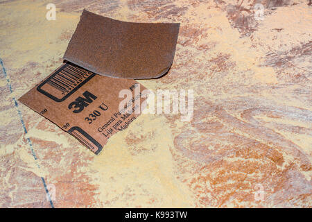 Sandpaper and sawdust on table top. Stock Photo