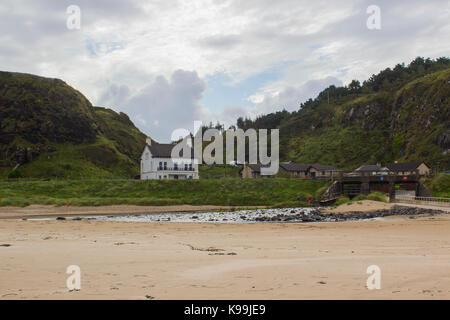 A well maintained detached house and garden with a river passing under a small bridge. Located on the beach front in Downhill in County Londonderry, N Stock Photo