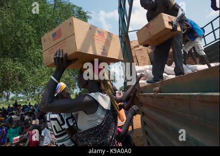 August 28, 2014 - Panweel Village - Kolnyang Payam, Bor County, South Sudan - Internally displaced refugees unload refined vegetable oil from a truck. Thousands of South Sudanese became internally displaced refugees in Jonglei and Juba following the outbreak of fighting between forces loyal to South Sudan president Salvar Kiir and his ex-vice president Rick Machar in December 2013. To help displaced and conflict-affected households return home and start the recovery process aid organizations have engaged in emergency response activities such as providing emergency food rations. (Credit Image:  Stock Photo