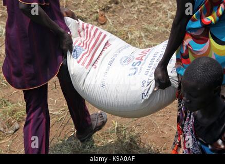 August 28, 2014 - Panweel Village - Kolnyang Payam, Bor County, South Sudan - Internally displaced refugees unload sacks of sorghum and split yellow peas from a truck. Thousands of South Sudanese became internally displaced refugees in Jonglei and Juba following the outbreak of fighting between forces loyal to South Sudan president Salvar Kiir and his ex-vice president Rick Machar in December 2013. To help displaced and conflict-affected households return home and start the recovery process aid organizations have engaged in emergency response activities such as providing emergency food rations Stock Photo